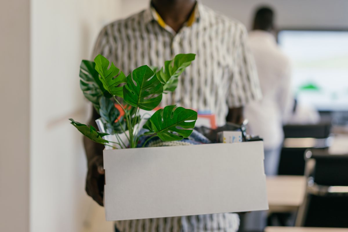 Office worker carrying a box of belongings during a relocation.